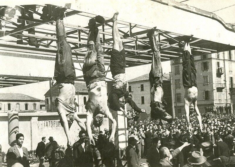 The dead body of Benito Mussolini next to his mistress Claretta Petacci and those of other executed fascists, on display in Milan on 29 April 1945, in Piazzale Loreto, the same place that the fascists had displayed the bodies of fifteen Milanese civilians a year earlier after executing them in retaliation for resistance activity. The photograph is by Vincenzo Carrese.